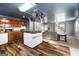 Open kitchen layout with an island, hanging pot rack, and wood cabinets, flowing into the living area at 5552 Smithfield Rd, Bowdon, GA 30108