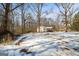 Expansive snowy yard with mature trees surrounding a cozy home with a porch at 5552 Smithfield Rd, Bowdon, GA 30108