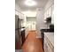 Galley kitchen with white cabinets, stainless steel appliances, and adjacent laundry area at 1448 Pine Log Ne Rd # C, Conyers, GA 30012