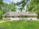 Serene backyard showcasing a well-kept lawn, patio, fire pit, and exterior home features at 45 Plantation Ln, Locust Grove, GA 30248
