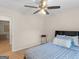 Bedroom with wood laminate flooring, ceiling fan, and comfortable-looking blue bedding at 45 Plantation Ln, Locust Grove, GA 30248