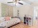 Sunlit bedroom showcasing wood laminate flooring, cube storage, and comfortable bed at 45 Plantation Ln, Locust Grove, GA 30248