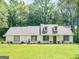 Charming one story home with a green yard and a welcoming green door, and dormers at 45 Plantation Ln, Locust Grove, GA 30248