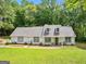 Charming one-story home features a well-manicured lawn and flower beds leading to a welcoming front entrance at 45 Plantation Ln, Locust Grove, GA 30248