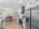 A stylish, renovated kitchen with white cabinets and stainless steel appliances near the dining area at 45 Plantation Ln, Locust Grove, GA 30248