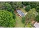 Lush green surroundings enhance this home's aerial view, illustrating its serene, secluded environment at 380 Grady Ave, Fayetteville, GA 30214