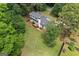 An aerial shot reveals a home surrounded by lush greenery, highlighting its private and wooded lot at 380 Grady Ave, Fayetteville, GA 30214
