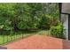 Large, well-maintained backyard surrounded by green trees and a black iron fence at 380 Grady Ave, Fayetteville, GA 30214