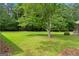 Manicured backyard with lush green grass and scattered trees at 380 Grady Ave, Fayetteville, GA 30214