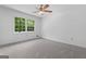 Bright bedroom featuring a ceiling fan, gray carpet, and a window offering natural light at 380 Grady Ave, Fayetteville, GA 30214