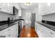 Bright kitchen with white cabinets, stainless steel appliances, and refinished hardwood floors at 380 Grady Ave, Fayetteville, GA 30214