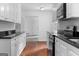 Modern kitchen with white cabinets, black countertops, and stainless-steel appliances at 380 Grady Ave, Fayetteville, GA 30214