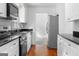 Galley kitchen featuring white cabinets, stainless steel appliances, and hardwood floors at 380 Grady Ave, Fayetteville, GA 30214