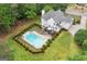Aerial view of a home with a sparkling pool, manicured lawn, and mature trees at 495 Stonehaven Dr, Fayetteville, GA 30215
