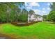Expansive backyard featuring a swimming pool, lush green lawn, and a charming white two-story home at 495 Stonehaven Dr, Fayetteville, GA 30215