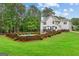 Sprawling backyard featuring manicured lawn, privacy fence, pool and mature trees at 495 Stonehaven Dr, Fayetteville, GA 30215