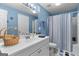 Inviting blue bathroom featuring a shower, vanity with sink, decor, and ample lighting, creating a fresh aesthetic at 495 Stonehaven Dr, Fayetteville, GA 30215