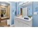 A well-lit bathroom featuring a vanity with a white sink, mirror, and a glimpse into the hallway at 495 Stonehaven Dr, Fayetteville, GA 30215