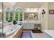 A bright bathroom features a jacuzzi tub, white vanity and large mirror at 495 Stonehaven Dr, Fayetteville, GA 30215