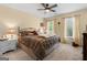 Relaxing bedroom featuring a plush bed, ceiling fan, and natural light from large windows at 495 Stonehaven Dr, Fayetteville, GA 30215