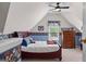 Attic bedroom featuring a cozy bed, dresser, carpet and whimsical sports-themed wallpaper at 495 Stonehaven Dr, Fayetteville, GA 30215