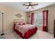 Comfortable bedroom with red bedding, window with red curtains and ceiling fan at 495 Stonehaven Dr, Fayetteville, GA 30215
