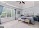 Relaxing bedroom with tray ceiling, large windows, and a decorative furniture bench at 495 Stonehaven Dr, Fayetteville, GA 30215