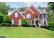Traditional brick home with a manicured lawn, blue shutters, and beautiful landscaping, perfect for suburban living at 495 Stonehaven Dr, Fayetteville, GA 30215