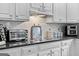 Updated kitchen featuring white cabinets, granite countertops, tiled backsplash, and stainless appliances at 495 Stonehaven Dr, Fayetteville, GA 30215
