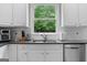 Bright kitchen with stainless appliances, white cabinets and a view to the backyard at 495 Stonehaven Dr, Fayetteville, GA 30215