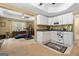 Compact kitchenette featuring white cabinets and appliances, open to the living area with exercise equipment at 495 Stonehaven Dr, Fayetteville, GA 30215