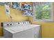 Bright laundry area features a Speed Queen washer/dryer with shelving, offering convenience and storage at 495 Stonehaven Dr, Fayetteville, GA 30215