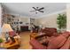 Spacious living room featuring hardwood floors, ceiling fan, a brick fireplace, and built-in shelving at 495 Stonehaven Dr, Fayetteville, GA 30215