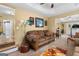 Cozy living room with a brown sofa, ceiling fan, and a unique colorful floor lamp on a carpeted floor at 495 Stonehaven Dr, Fayetteville, GA 30215