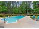 Private in-ground pool surrounded by mature landscaping and a fenced yard at 495 Stonehaven Dr, Fayetteville, GA 30215