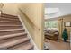 Carpeted staircase leading to a bright living room with a ceiling fan and a decorative Christmas tree at 495 Stonehaven Dr, Fayetteville, GA 30215