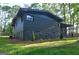 View of back exterior of home with dark painted brick and stone foundation at 1147 Tanglewood Rd, Jonesboro, GA 30236