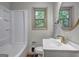 Bright bathroom featuring a tub with shower, stylish vanity, and a window offering natural light and outdoor views at 1147 Tanglewood Rd, Jonesboro, GA 30236