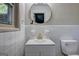 Bathroom with updated vanity, round mirror and a window with natural light at 1147 Tanglewood Rd, Jonesboro, GA 30236