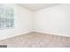 Bright bedroom featuring neutral carpet, a window with blinds, and freshly painted walls at 1716 Anniston Dr, Mcdonough, GA 30253