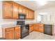 Well-lit kitchen featuring granite countertops, wood cabinets, and black appliances at 1716 Anniston Dr, Mcdonough, GA 30253