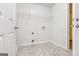 Clean laundry room equipped with tile flooring, washer hookups, and a storage shelf at 1716 Anniston Dr, Mcdonough, GA 30253