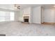 Spacious carpeted living room with a cozy brick fireplace and built-in shelving for storage and decor at 1716 Anniston Dr, Mcdonough, GA 30253