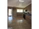 Open kitchen with tile floor, cabinets, dual basin sink, and window above sink at 9163 Fair Sw St, Covington, GA 30014