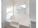 Bright bathroom features a white tiled tub, window, and neutral tile floors at 1281 Heartwood Ave, Mcdonough, GA 30253