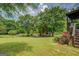 Wide backyard with mature trees, fenced area, and garden with colorful roses at 75 Puppy Chase, Social Circle, GA 30025