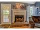 Living room fireplace with brick hearth, decorative mantel, and glass door to the backyard at 75 Puppy Chase, Social Circle, GA 30025