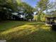 Expansive backyard featuring lush lawn, mature trees, and outbuildings, perfect for outdoor activities and relaxation at 104 Hillmont Dr, Woodstock, GA 30188