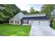 Charming home featuring an attached two-car garage, landscaped yard, and traditional shutters at 104 Hillmont Dr, Woodstock, GA 30188