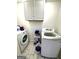 Functional laundry room with modern washer and dryer and overhead storage at 104 Hillmont Dr, Woodstock, GA 30188